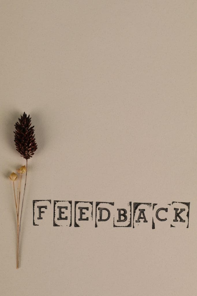 een wit vel met daarop een roos en het woord feedback