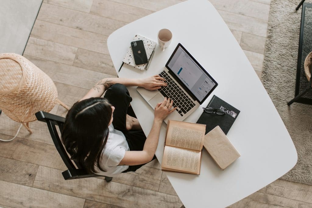 Een vrouw die zit te werken aan zowel werk als privé zaken. Een vertoning waar de werk privé balans in evenwicht is.
