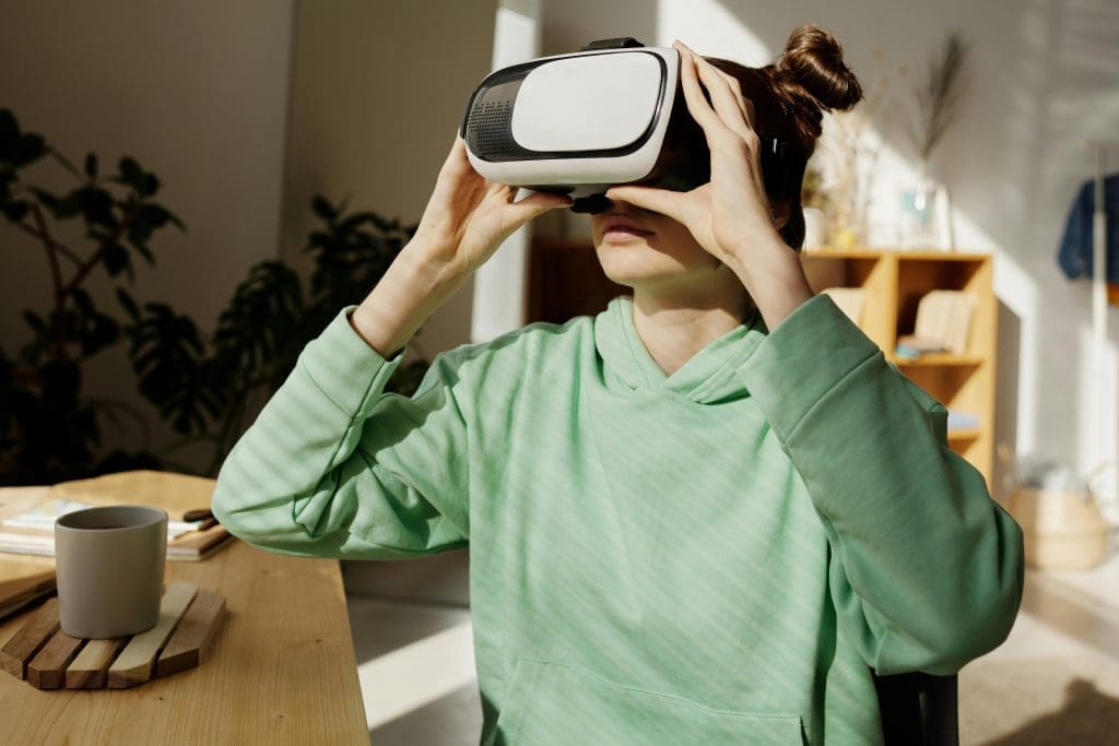Een vrouw die achter haar bureau zit met een VR-bril op om producten van een winkel te testen